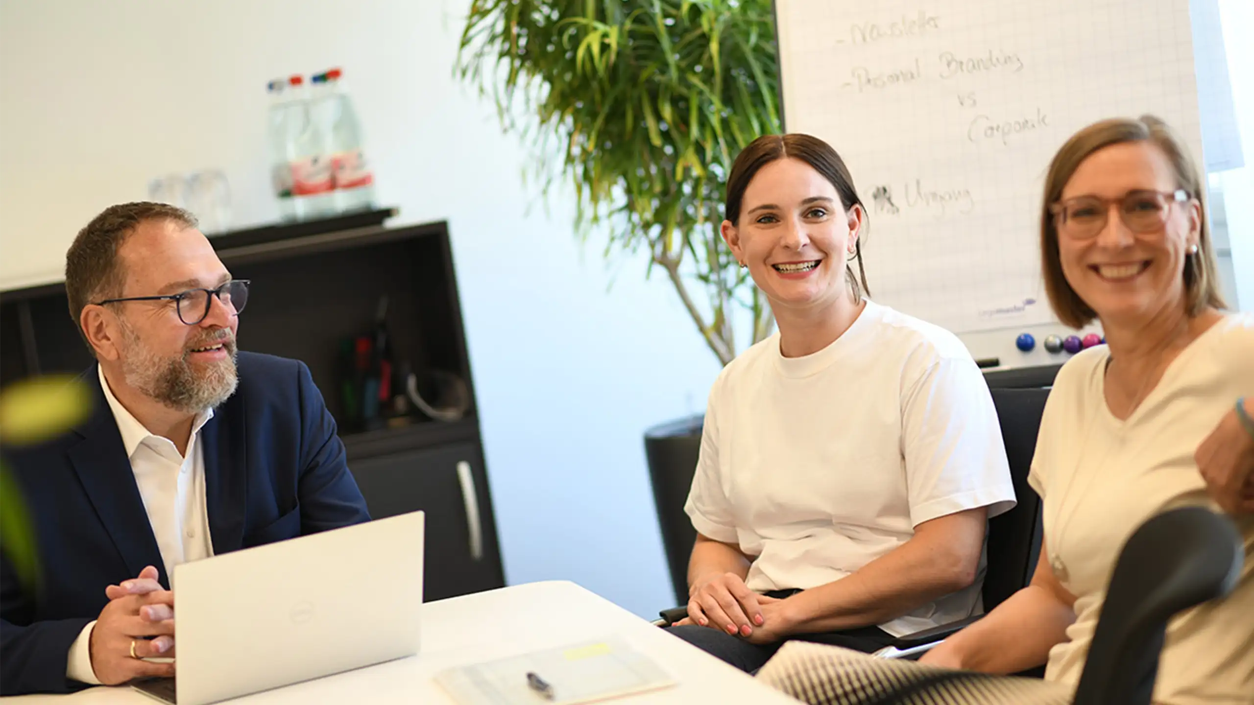 Das Portfolio beim Impact Investor Abacus alpha: Drei mitarbeitende sitze in einem modernen Büro.